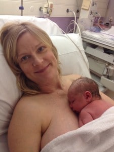 Smiling mother skin to skin with newborn baby