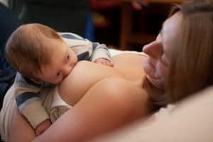 laid back breastfeeding, picture taken from over mother's shoulder, baby looking up to mother