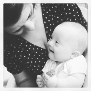 Black and white close up photo of mum with smiling baby